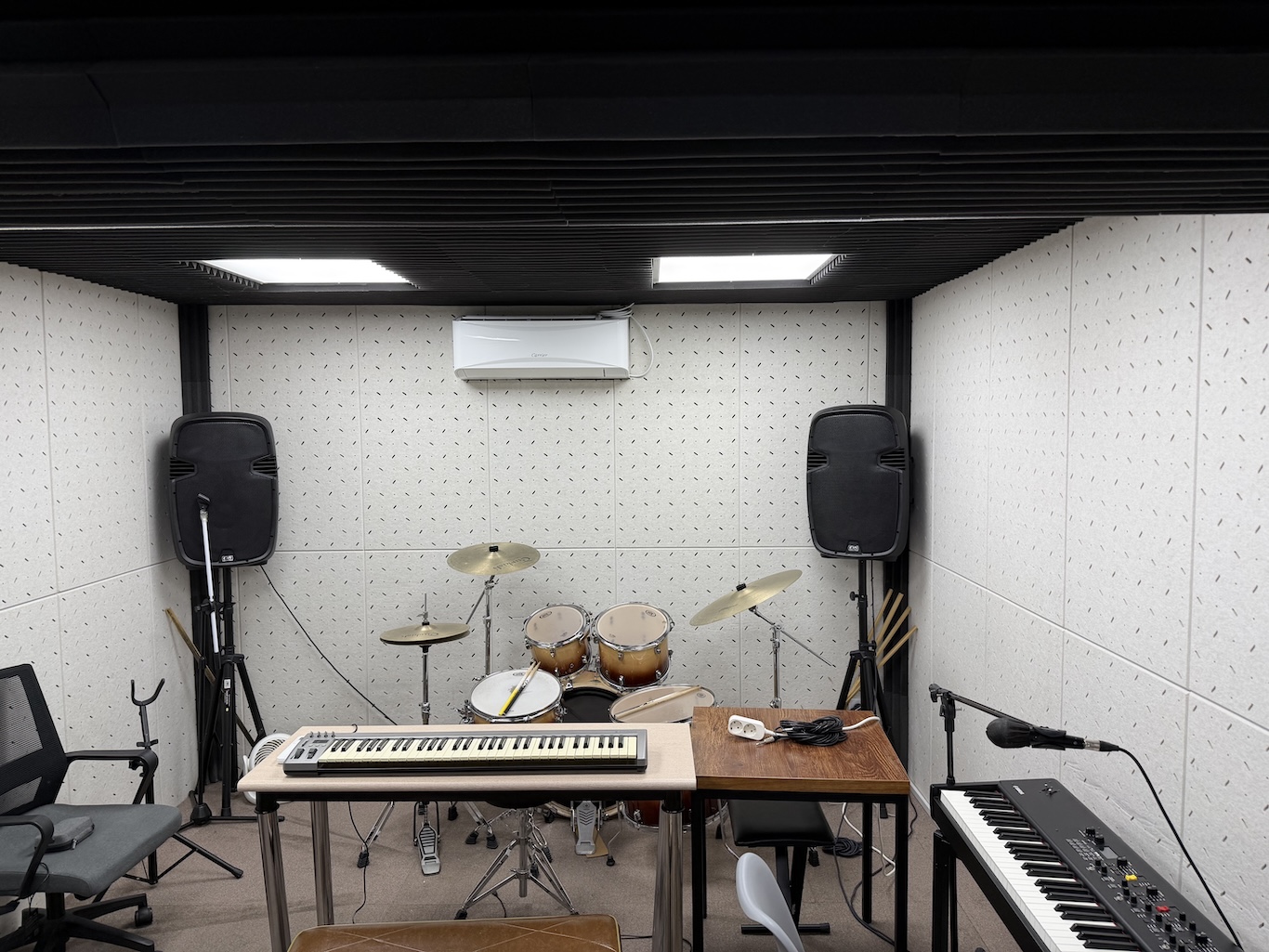소리마을 내부. 건반, 드럼, 모니터 스피커가 밝고 화사한 조명과 함께 모습을 드러낸다.